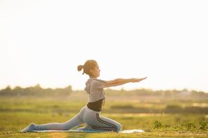 Portrait of a Young Woman performing Yoga outside in sunny bright light. photo