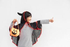 Funny halloween kid concept, little cute girl with costume halloween ghost scary he holding orange pumpkin ghost on hand, on white background photo