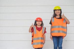 retrato de una hermana con un sombrero de construcción. foto