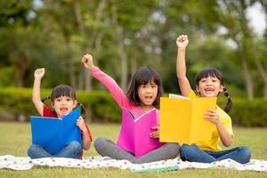 tres niños leyendo en el parque. foto