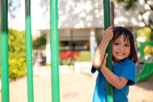 linda niña divirtiéndose en un patio de recreo al aire libre en verano foto