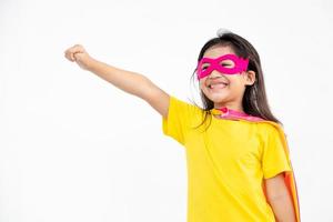 Funny little girl playing power super hero over white background. Superhero concept. photo