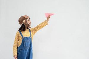 niño asiático feliz jugando con un avión de papel foto