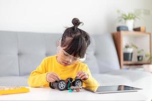 Little girls having fun in a workshop coding robot car photo