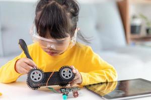 Little girls having fun in a workshop coding robot car photo
