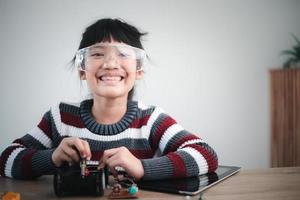 Asia students learn at home in coding robot cars and electronic board cables in STEM, STEAM, mathematics engineering science technology computer code in robotics for kids concept. photo