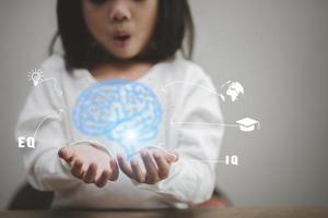 las manos de la niña sosteniendo el cerebro. para el desarrollo por delante del concepto de persona pequeña. dirección de progreso con visión de futuro. foto