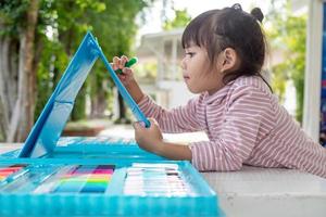 Little kids drawing with a colored pencil is a good activity for improving creative art and handwriting skills in children. Concept picture for education and learning hobby. photo