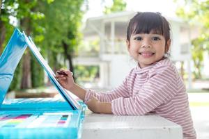 Little kids drawing with a colored pencil is a good activity for improving creative art and handwriting skills in children. Concept picture for education and learning hobby. photo