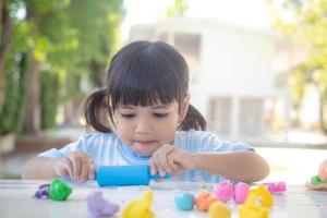 los niños asiáticos juegan con formas de moldeo de arcilla, aprendiendo a través del juego foto