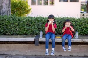 Kids eating outdoors at the school. Healthy school breakfast for children. Sandwich time. photo