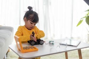Asia students learn at home in coding robot cars and electronic board cables in STEM, STEAM, mathematics engineering science technology computer code in robotics for kids concept. photo