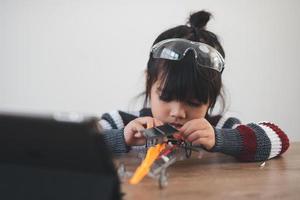 Inventive kid constructing robot cars at home photo