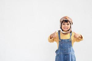 dreams of flight little child girl playing with a pilot hat on white background photo