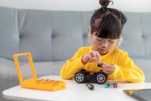 Little girls having fun in a workshop coding robot car photo