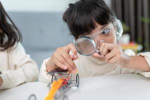 Inventive kid constructing robot cars at home photo