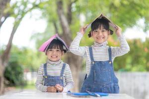 lindos niños asiáticos leyendo un libro sobre la mesa foto