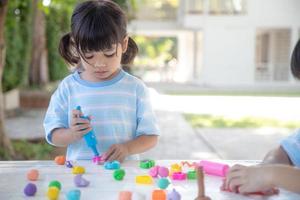 los niños asiáticos juegan con formas de moldeo de arcilla, aprendiendo a través del juego foto