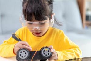 Little girls having fun in a workshop coding robot car photo