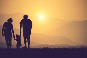 silueta de una familia feliz y feliz puesta de sol foto