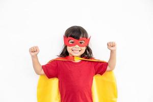 niña pequeña juega superhéroe. niño sobre el fondo blanco. concepto de poder femenino foto