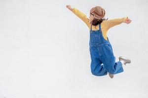 dreams of flight little child girl playing with a pilot hat on white background photo