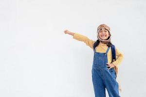 sueños de vuelo niña pequeña jugando con un sombrero de piloto sobre fondo blanco foto