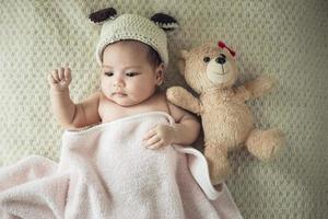 newborn baby on a blanket with a teddy photo