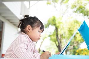 Little kids drawing with a colored pencil is a good activity for improving creative art and handwriting skills in children. Concept picture for education and learning hobby. photo