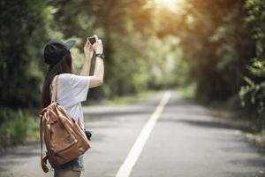 Outdoor summer smiling lifestyle portrait of pretty young woman having fun with camera travel photo of photographer Making pictures