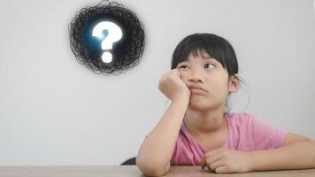 asian little girl thinking with question mark photo