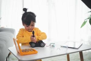 Asia students learn at home in coding robot cars and electronic board cables in STEM, STEAM, mathematics engineering science technology computer code in robotics for kids concept. photo