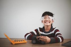 Inventive kid constructing robot cars at home photo