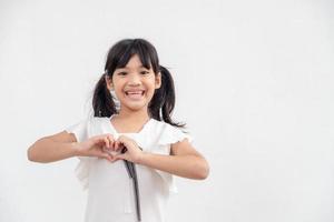 Little girl hands making a heart shape on white background photo