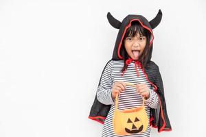 Funny Halloween Kid Concept, little cute girl with costume Halloween ghost scary he holding orange pumpkin ghost on hand, on white background photo
