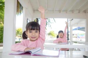 Little Asian girl at lesson in the classroom photo