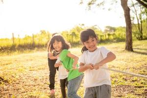 niños jugando tira y afloja en el parque en sunsut foto