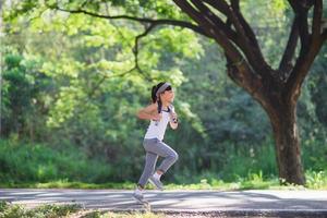 happy child girl running in the park in summer in nature. warm sunlight flare. asian little is running in a park. outdoor sports and fitness, exercise and competition learning for kid development. photo