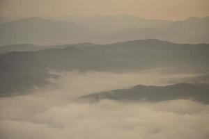 capa de montañas y niebla durante la puesta de sol foto