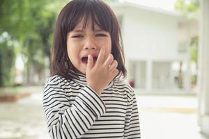 Portrait of Asian crying little girl with little rolling tears weeping emotion, hurt in pain fit drops cheek. Young crying panic drama Asian toddler. photo