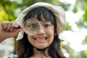 Girl looking through a magnifying glass photo