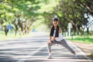 Linda chica asiática ejercicio en fondo gardent foto