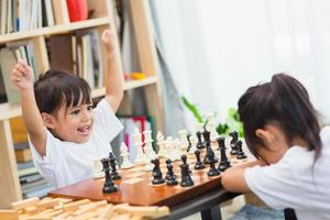 Kids playing chess - one of them just captured a pawn and celebrates photo