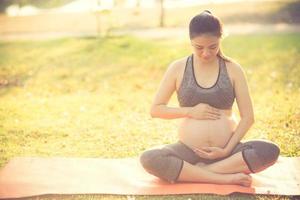 healthy pregnant woman doing yoga in nature outdoors.Vintage color photo