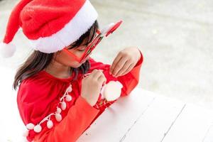 Asian little girl in red Santa hat on white background. photo