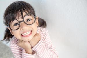 funny Asian child girl wearing glasses on a white background photo