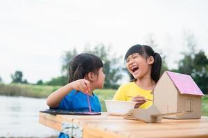 Asian sibling children drawing and painting colouring on the paper photo