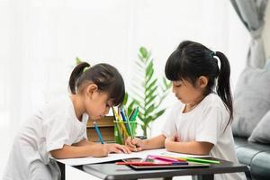 coronavirus covid-19 y aprendizaje desde el hogar, concepto de niño escolar en casa. los niños pequeños estudian en línea aprendiendo desde casa con una computadora portátil. foto