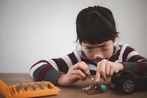 Asia students learn at home in coding robot cars and electronic board cables in STEM, STEAM, mathematics engineering science technology computer code in robotics for kids concept. photo