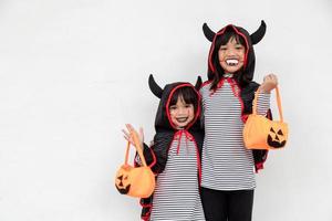 happy Halloween two children in Halloween costumes and with pumpkins on white background photo